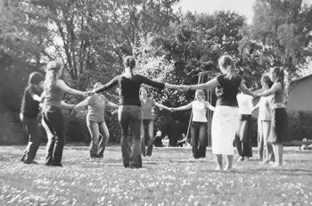 Menschen stehen im Kreis und halten sich an den Händen